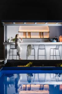 a person standing in a kitchen next to a pool at Quartano Suites by Heliessa, Adults Only in Naousa