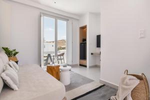 a white living room with a couch and a kitchen at Quartano Suites by Heliessa, Adults Only in Naousa