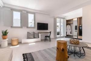 a living room with a table and a tv at Quartano Suites by Heliessa, Adults Only in Naousa