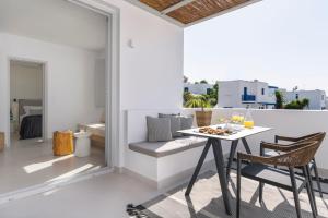 a dining room with a table and chairs on a balcony at Quartano Suites by Heliessa, Adults Only in Naousa