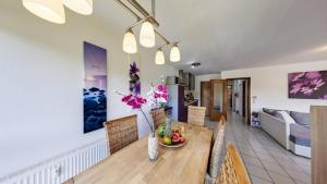 Un comedor y una sala de estar con mesa y sillas. en Ferienwohnung Seeblick I, en Schalkenmehren