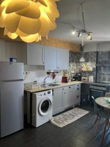 a kitchen with a white refrigerator and a dishwasher at colored houses in Ierapetra