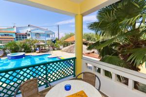a balcony with a table and a swimming pool at Aegean Sun Hotel in Skala Rachoniou