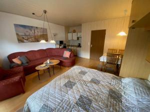 a living room with a red couch and a table at Ferienwohnung "Strandoase" in Burhave +11 photos