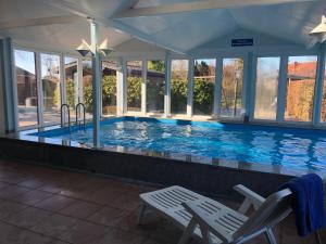 a large swimming pool with two chairs and a table at Ferienwohnung "Strandoase" in Burhave