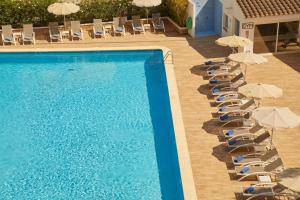 a row of chairs and umbrellas next to a swimming pool at Hotel Joan Miró Museum in Palma de Mallorca