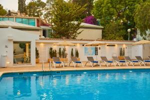 a swimming pool with chairs and umbrellas next to a house at Hotel Joan Miró Museum in Palma de Mallorca