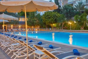 a swimming pool with lounge chairs and an umbrella at Hotel Joan Miró Museum in Palma de Mallorca