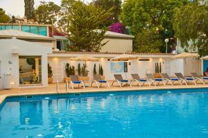 a pool with chairs and umbrellas next to a house at Hotel Joan Miró Museum in Palma de Mallorca