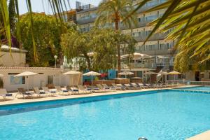 a large swimming pool with chairs and umbrellas at Hotel Joan Miró Museum in Palma de Mallorca