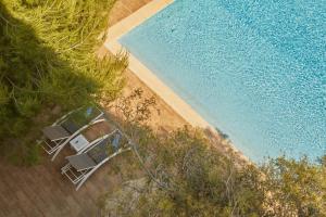 an overhead view of a pool with chairs next to a beach at Hotel Joan Miró Museum in Palma de Mallorca