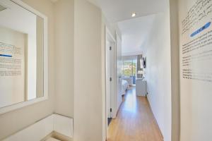a hallway with white walls and wood floors and a window at Hotel Joan Miró Museum in Palma de Mallorca
