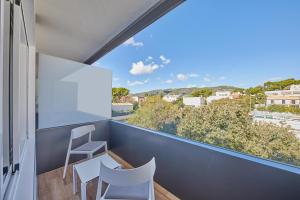 a balcony with white chairs and a large window at Hotel Joan Miró Museum in Palma de Mallorca