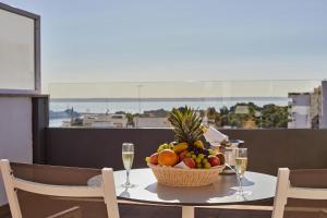 a table with a basket of fruit and glasses of wine at Hotel Joan Miró Museum in Palma de Mallorca
