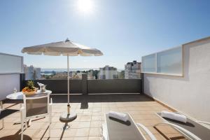 a balcony with an umbrella and a table and chairs at Hotel Joan Miró Museum in Palma de Mallorca
