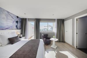 a hotel room with a bed and a chair and a window at Hotel Joan Miró Museum in Palma de Mallorca