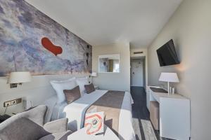 a hotel room with a bed and a couch at Hotel Joan Miró Museum in Palma de Mallorca