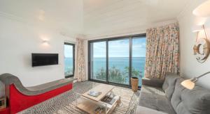 a living room with a couch and a large window at OurMadeira - Cottage do Mar, secluded in Arco da Calheta