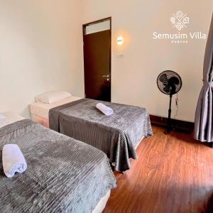 a room with two beds and a fan at Sierra by Semusim Villa in Cianjur