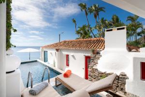 a villa with a swimming pool and the ocean at OurMadeira - Cottage do Mar, secluded in Arco da Calheta