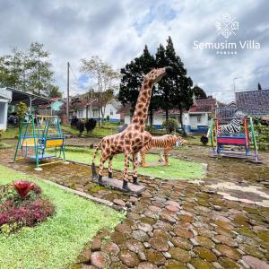 a statue of a giraffe and a zebra on a playground at Sierra by Semusim Villa in Cianjur
