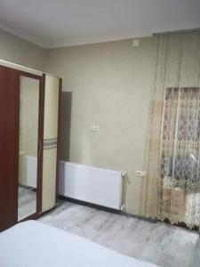 a bedroom with a bed and a window and a mirror at Eddy in Borjomi