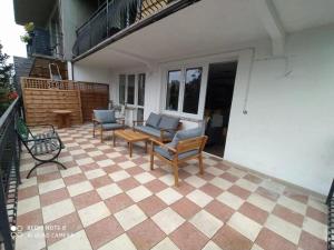 a patio with two chairs and a couch and a table at Willa Loka Apartamenty in Władysławowo