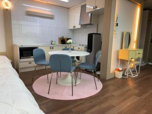una cucina con un tavolo e sedie in una stanza di Hongdae sub 1min a Seul