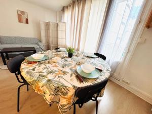 een eettafel met een tafelkleed erop bij Appartement rue Lecourbe in Parijs