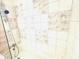 een badkamer met een douche en marmeren tegels bij Appartement rue Lecourbe in Parijs +2 foto's