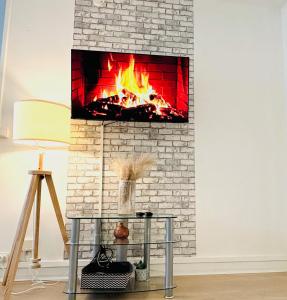 een stenen open haard met een vuur erin bij Appartement rue Lecourbe in Parijs