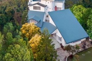 an overhead view of a white house with a blue roof at Boutique Villa w Bonfire & BBQ, Mussoorie Foothills in Dehradun