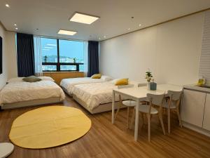 una camera da letto con due letti, un tavolo e delle sedie di Hongdae sub 1min a Seul