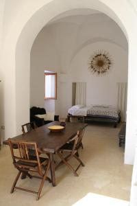 a dining room with a table and a bed at Masseria Autigne in Otranto