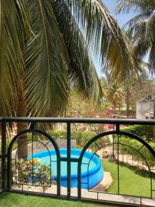 Sali PoulangにあるVILLA TABARA HOTEL LA TERANGA Saly Senegalのプールの景色を望むバルコニーが備わります。