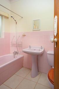 a pink bathroom with a sink and a tub and a toilet at 19 on Durban Row in Colesberg +32 photos