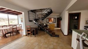 a living room with a spiral staircase and a table at Villa Harmony in Charco del Palo