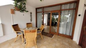 a dining room with a glass table and chairs at Villa Harmony in Charco del Palo