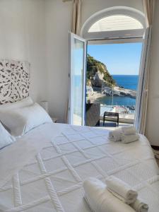 une chambre avec un lit blanc avec vue sur l'océan dans l'établissement Divina Seaside Suite Ischia, à Ischia
