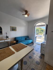 a living room with a blue couch and a table at Divina Seaside Suite Ischia in Sant'Angelo D'Ischia