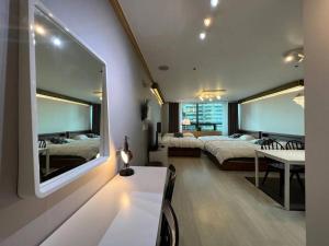 una camera da letto con due letti, un tavolo e uno specchio di Hongdae sub 1min a Seul