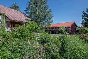 een tuin voor een huis met bloemen bij Metsäsydän huonemajoitus in Puumala