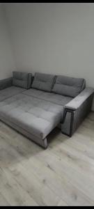 un grande divano grigio appoggiato su un pavimento in legno di Apartment Karkop a Archis