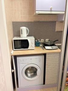 a kitchen with a microwave and a washing machine at Лавандовий світанок Однокімнатна квартира біля ЦУМу в центрі Полтави Мережа AlexApartments Документи для відряджень Безконтатне заселення 24-7 in Poltava