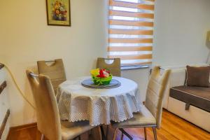 una mesa de comedor con un tazón de flores. en Apartman Ozimice 2, en Bihać