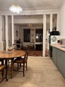 a kitchen and living room with a wooden table and chairs at "La Grenouille" Centre historique - Les Terres du Roy in Avallon