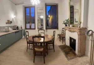 a dining room with a table and a fireplace at "La Grenouille" Centre historique - Les Terres du Roy in Avallon