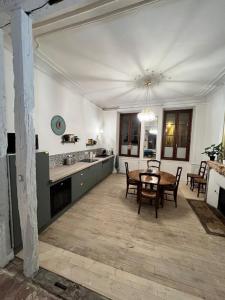 a kitchen and dining room with a table and chairs at "La Grenouille" Centre historique - Les Terres du Roy in Avallon