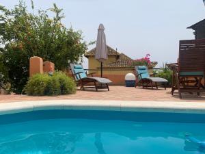 a group of chairs sitting next to a swimming pool at Apartamento con jacuzzi y terraza con opcion a Piscina Privada in Almuñécar