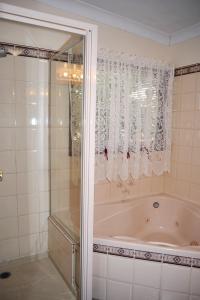 
a bathroom with a tub and a shower curtain at Cuddledoon Cottages Rutherglen in Rutherglen
